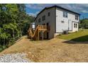 Back of home showing wood stairs and deck in yard with unfinished landscaping at 2387 Highpoint Rd, Snellville, GA 30078