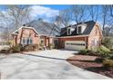 A side view of a brick home featuring an attached garage and a well-maintained landscape at 4051 Ridgehurst Se Dr, Smyrna, GA 30080