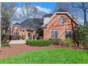 Charming brick home with manicured lawn, mature trees, and classic architectural details at 4051 Ridgehurst Se Dr, Smyrna, GA 30080