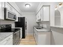 Modern kitchen with stainless steel appliances, granite countertops, and white cabinetry providing a sleek cooking space at 3110 Pine Heights Ne Dr, Atlanta, GA 30324