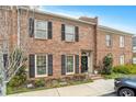 Charming brick townhome with black shutters, a black door, and manicured landscaping at 8 Kings Walk Ne, Atlanta, GA 30307