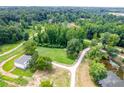 An aerial view reveals a private estate home surrounded by lush forests and a tranquil pond at 878 Forrester Cemetery Rd, Covington, GA 30014