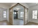 Stylish interior view featuring unique barn doors, light hardwood floors, and white trim accents at 2427 Wolf Meadow Ln, Buford, GA 30518