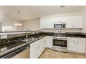 Modern kitchen with stainless steel appliances, dark countertops, and white cabinetry at 621 Shadow Lake Dr, Lithonia, GA 30058