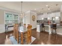 Bright dining area with stylish chandelier, wood floors, and adjacent to a modern kitchen at 2659 Village Park Bnd, Duluth, GA 30096