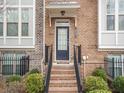 Inviting townhouse front entrance with brick steps, wrought iron railing, and well-kept landscaping at 2659 Village Park Bnd, Duluth, GA 30096