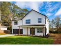 Charming two-story home with black trimmed windows, a well-manicured lawn and inviting, covered front entry at 221 Cobb St, Palmetto, GA 30268
