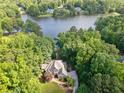 Aerial view of a lakeside home surrounded by lush greenery and other waterfront properties at 210 Lawn Market, Sharpsburg, GA 30277