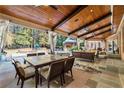 Spacious covered patio with a dining area, lounge seating, and views of the pool and backyard at 1050 Carnoustie Ln, Alpharetta, GA 30005