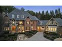 Charming brick home with manicured landscaping, cobblestone driveway, and well-lit entrance, creating a cozy and inviting atmosphere at 1050 Carnoustie Ln, Alpharetta, GA 30005