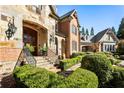 Close up of a lovely entryway with brick and stonework, with beautiful garden and lawn design elements at 1050 Carnoustie Ln, Alpharetta, GA 30005