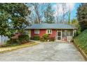 Cozy single-story home featuring a screened porch, mature landscaping, and a concrete driveway at 42 W Belle Isle Ne Rd, Atlanta, GA 30342