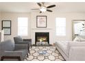 Comfortable living room with a fireplace, ceiling fan, stylish furniture, and neutral decor at 2765 Sandy Rd, Conyers, GA 30013