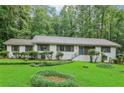 Inviting single-Gathering home showcasing a lush green lawn, manicured bushes, and a welcoming front porch at 2950 Duke Of Gloucester, Atlanta, GA 30344