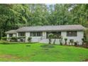 Attractive home surrounded by mature trees, a lush green lawn, and decorative shrubbery adding curb appeal at 2950 Duke Of Gloucester, Atlanta, GA 30344