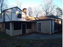 Exterior view of home with a screened porch, attached accessory building, and mature trees at 9031 Thornton Rd, Jonesboro, GA 30236