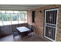 Enclosed porch featuring a brick wall, decorative screen door, table and chairs at 9031 Thornton Rd, Jonesboro, GA 30236