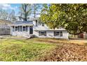 Split-level home with fresh paint, black shutters, and mature trees on a well-maintained lawn at 8331 Attica Ct, Jonesboro, GA 30238