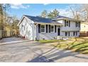 Split-level home featuring updated white paint, dark shutters, and a long driveway at 8331 Attica Ct, Jonesboro, GA 30238