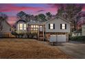 Exterior shot of a two-story home with a two-car garage and mature landscaping during dusk at 1117 Mountain Springs Nw Dr, Kennesaw, GA 30144