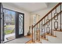 Welcoming entryway with stylish black metal staircase, hardwood floors, and a view of the front yard at 1524 Chateau Dr, Dunwoody, GA 30338