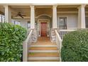 Inviting front porch with stone pillars, wood steps, and a classic red front door at 170 Maple View Ct, Dallas, GA 30157