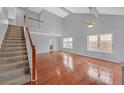 Spacious living room features soaring ceilings, a ceiling fan, hardwood floors, and staircase to the second floor at 560 Woodstone Rd, Lithonia, GA 30058