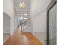 Grand foyer with high ceilings, hardwood floors, a chandelier, and a staircase leading to the second floor at 10440 Cranchester Way, Alpharetta, GA 30022