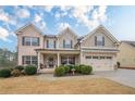 Beautiful two-story home with a brick and siding exterior, front porch, and well-maintained landscaping at 1050 Silver Thorne Dr, Loganville, GA 30052