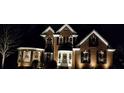 Beautiful two-story home exterior adorned with seasonal wreaths and festive lighting at night at 1210 Thistle Gate Path, Lawrenceville, GA 30045