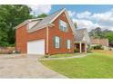 Brick home featuring an attached garage, complemented by green shutters and lush landscaping at 3641 Willow Club Dr, Loganville, GA 30052