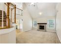 Open-concept living area with a fireplace, vaulted ceilings, and staircase at 3641 Willow Club Dr, Loganville, GA 30052