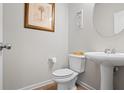 Half bath features a pedestal sink, round mirror, and tiled floors at 5152 Rapahoe Trl, Atlanta, GA 30349