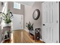 Bright foyer with high ceilings, hardwood floors, plants, decorative mirror, and a white front door at 1241 Skylar Ridge Cir, Buford, GA 30519