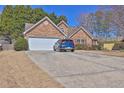 Exterior view of a charming one-story home with stone accents and attached garage on a concrete driveway at 1241 Skylar Ridge Cir, Buford, GA 30519