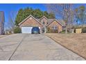 Inviting single-story home featuring a beautiful stone facade, well-manicured lawn, and convenient driveway parking at 1241 Skylar Ridge Cir, Buford, GA 30519