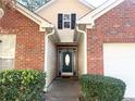 An inviting front entrance with a stylish door, surrounded by brick and lush greenery at 396 Avian Forest Dr, Stockbridge, GA 30281