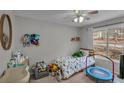 Bright bedroom featuring a ceiling fan, a large window and toys scattered about at 4804 Mceachern Way, Powder Springs, GA 30127