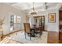 Refined dining room with coffered ceiling, hardwood floors, French doors, and stylish chandelier at 9070 Waits Ferry Xing, Johns Creek, GA 30097