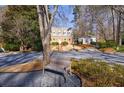 A brick house with a dormer window, surrounded by trees and shrubs and a bench nearby at 2650 Peachtree Battle Nw Pl, Atlanta, GA 30327