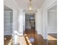 Open hallway with hardwood floors, decorative columns, and a view of the staircase at 2650 Peachtree Battle Nw Pl, Atlanta, GA 30327