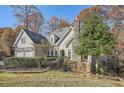 A two-story home with a stone chimney, a waterfall feature, and mature trees on the property at 3330 Valley Vista Se Rd, Smyrna, GA 30080