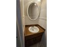 Quaint powder room with an oval mirror, single sink, and wood vanity at 400 Prince Of Wales, Stone Mountain, GA 30083