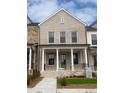 Charming two-story townhome boasts a light brick facade, covered porch, and well-manicured lawn at 110 Chiswick Cir # 40, Alpharetta, GA 30009