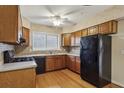 Functional kitchen features wooden cabinets, black appliances, and laminate floors at 310 Comeragh Se, Smyrna, GA 30080