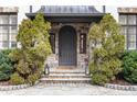 Stunning stone front door with a stately gray door, flanked by green shrubbery at 675 W Paces Ferry Nw Rd, Atlanta, GA 30327