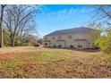 A view of the expansive backyard area that features a manicured lawn and mature trees at 6884 Robinson St, Lithonia, GA 30058