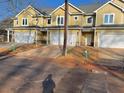 View of townhomes showcasing a modern exterior with neutral siding and attached one-car garages at 6884 Robinson St, Lithonia, GA 30058