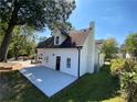 Rear view of a white home, featuring a patio and well-maintained lawn and new chimney at 180 S Alexander St, Buford, GA 30518