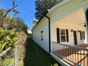 Side view of a white home with black shutters, showcasing the porch and well-maintained yard at 180 S Alexander St, Buford, GA 30518